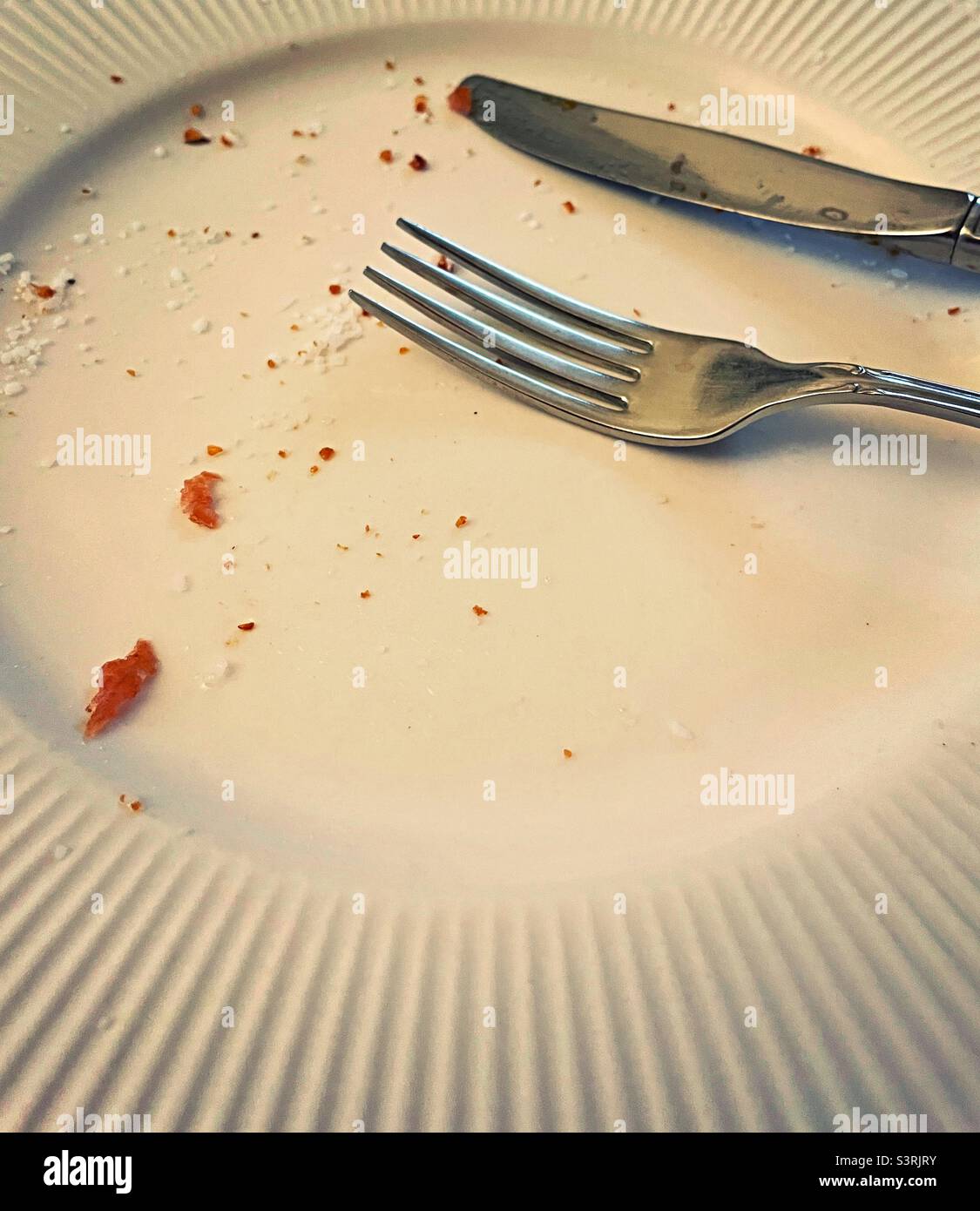 Close up of silverware on a dinner plate after a meal, 2022 - Smartphone Captured Stock Image
