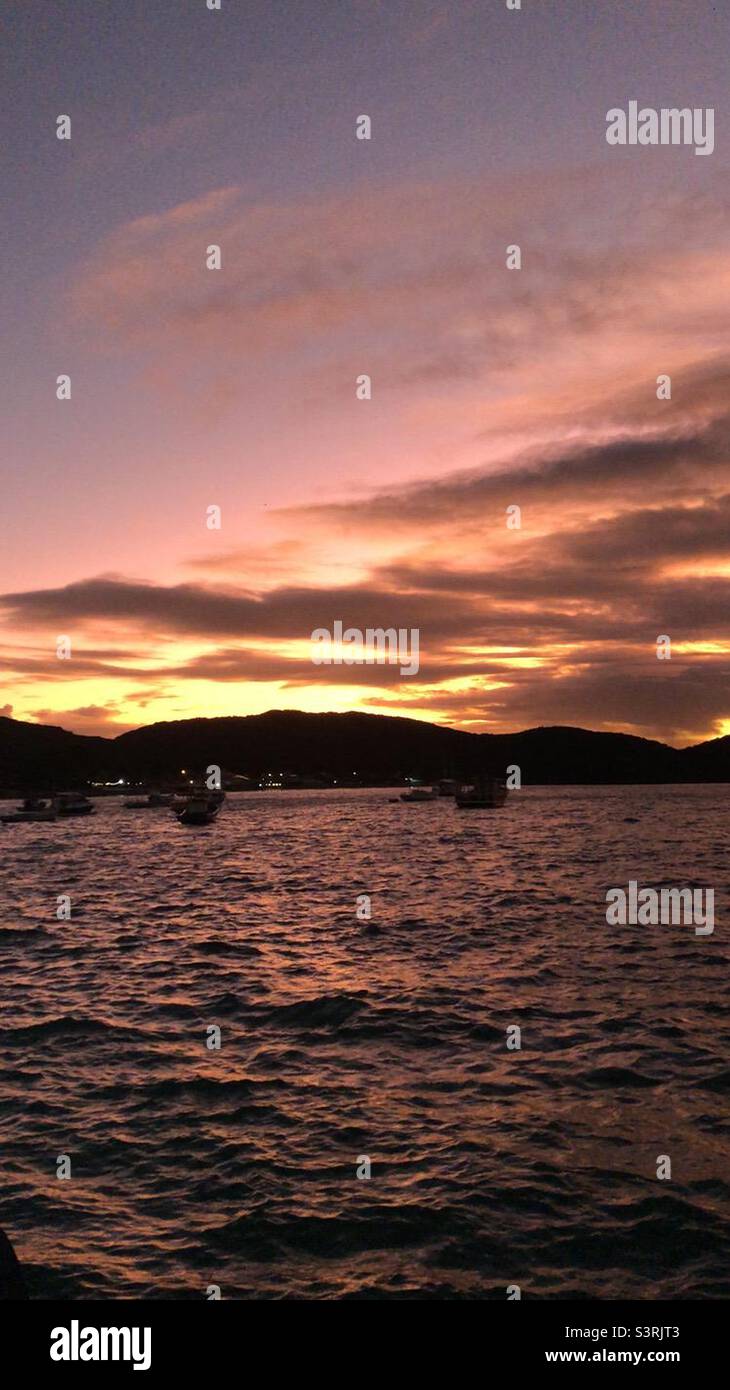 A beautiful sunset on the horizon over water. - Smartphone Captured Stock Image