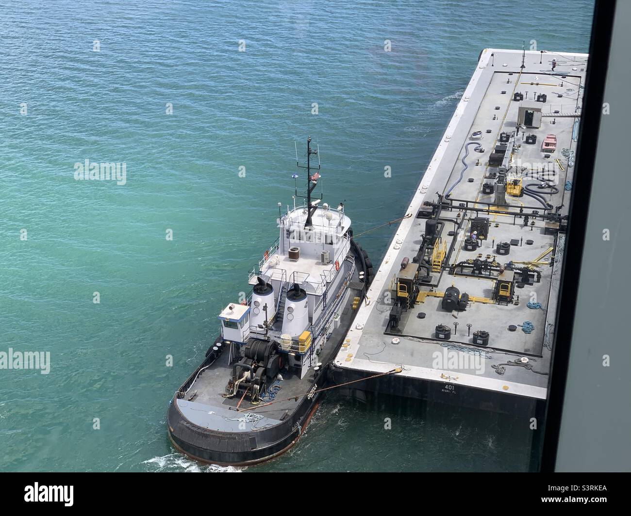 March, 2022, a tugboat and a barge next to a cruise ship, Port Miami, Miami, Florida, United States - Smartphone Captured Stock Image