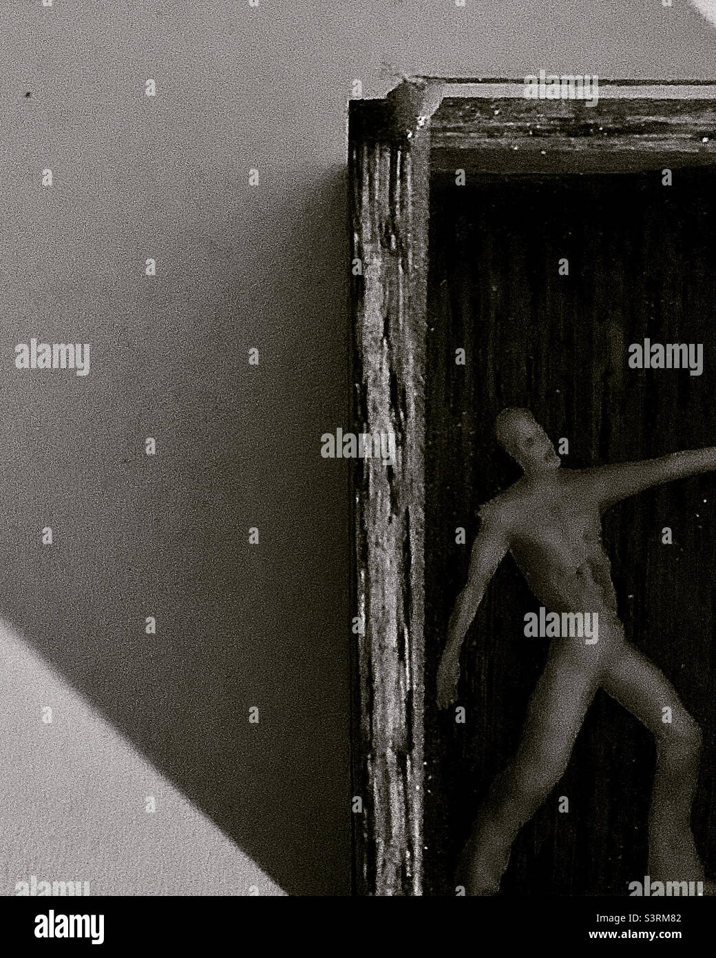 Eerie black and white of  tiny man trapped in a box - Smartphone Captured Stock Image