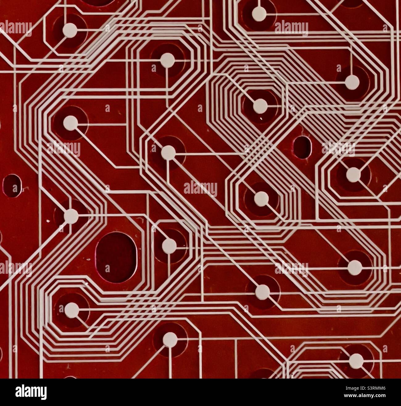 A section of a printed circuit board against a red background - Smartphone Captured Stock Image