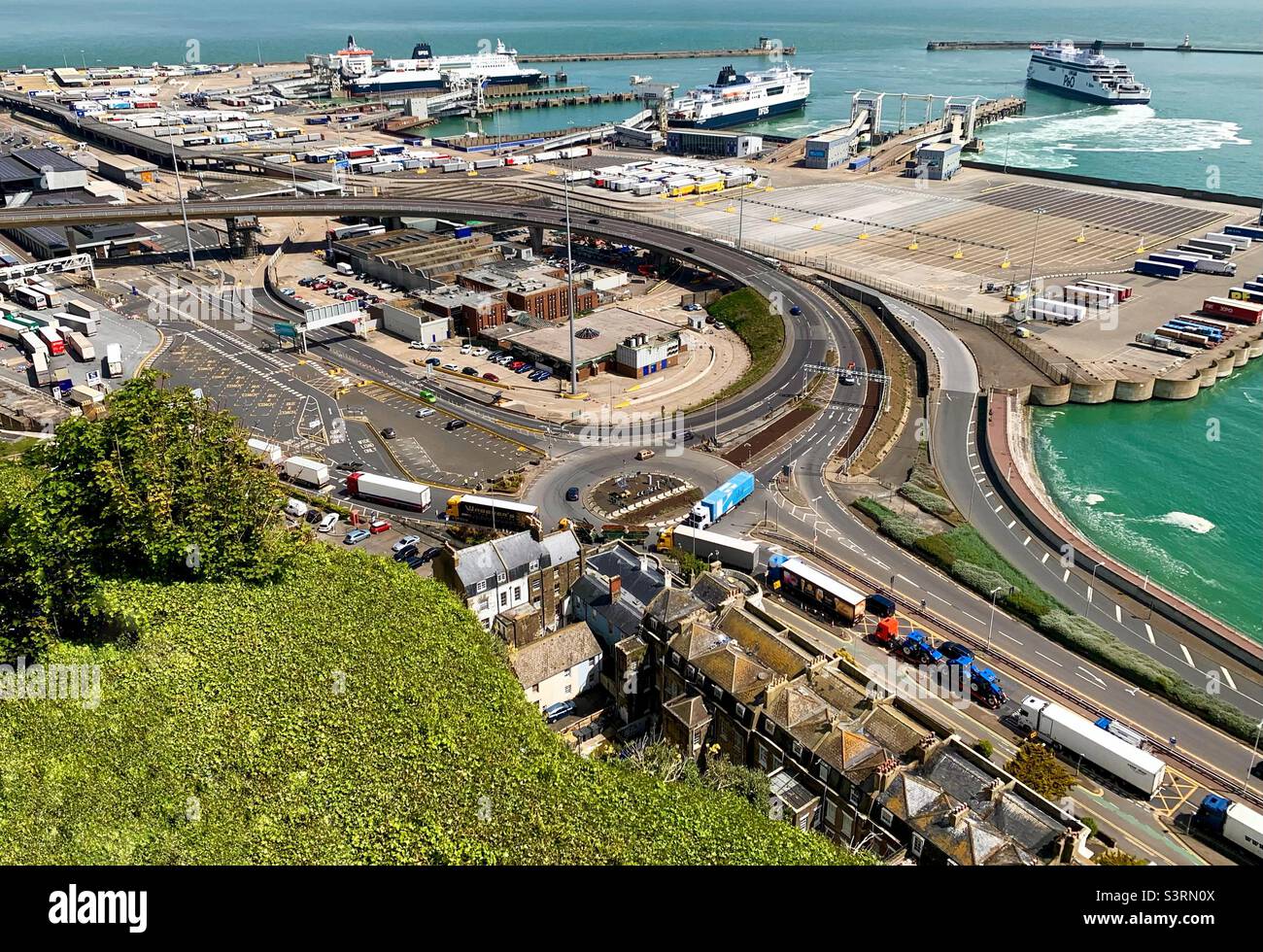 P&O ferry departing the port of Dover Kent, with long lines of lorries queuing at the port entrance for departure. - Smartphone Captured Stock Image
