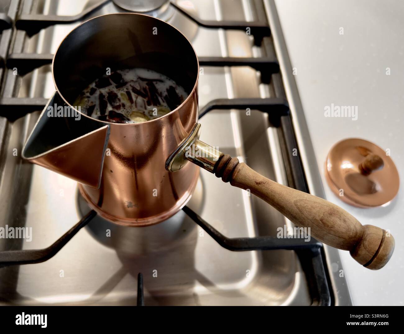 https://c8.alamy.com/comp/S3RN6G/antique-copper-turkish-coffee-pot-on-stove-with-chair-latte-ingredients-S3RN6G.jpg