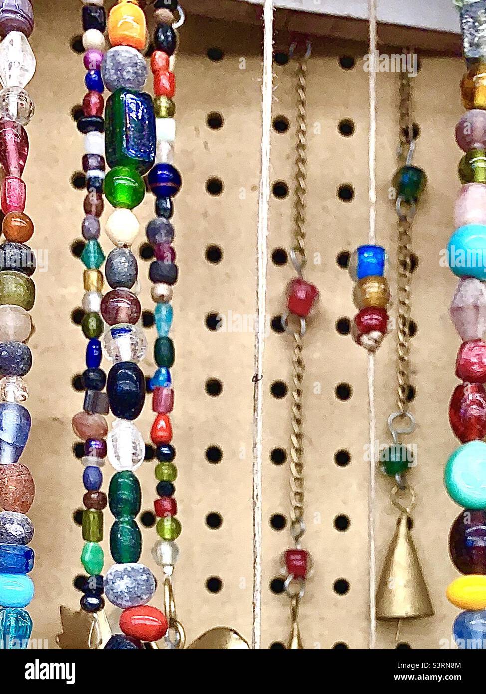 Several colorful bead strands hanging on display - Smartphone Captured Stock Image