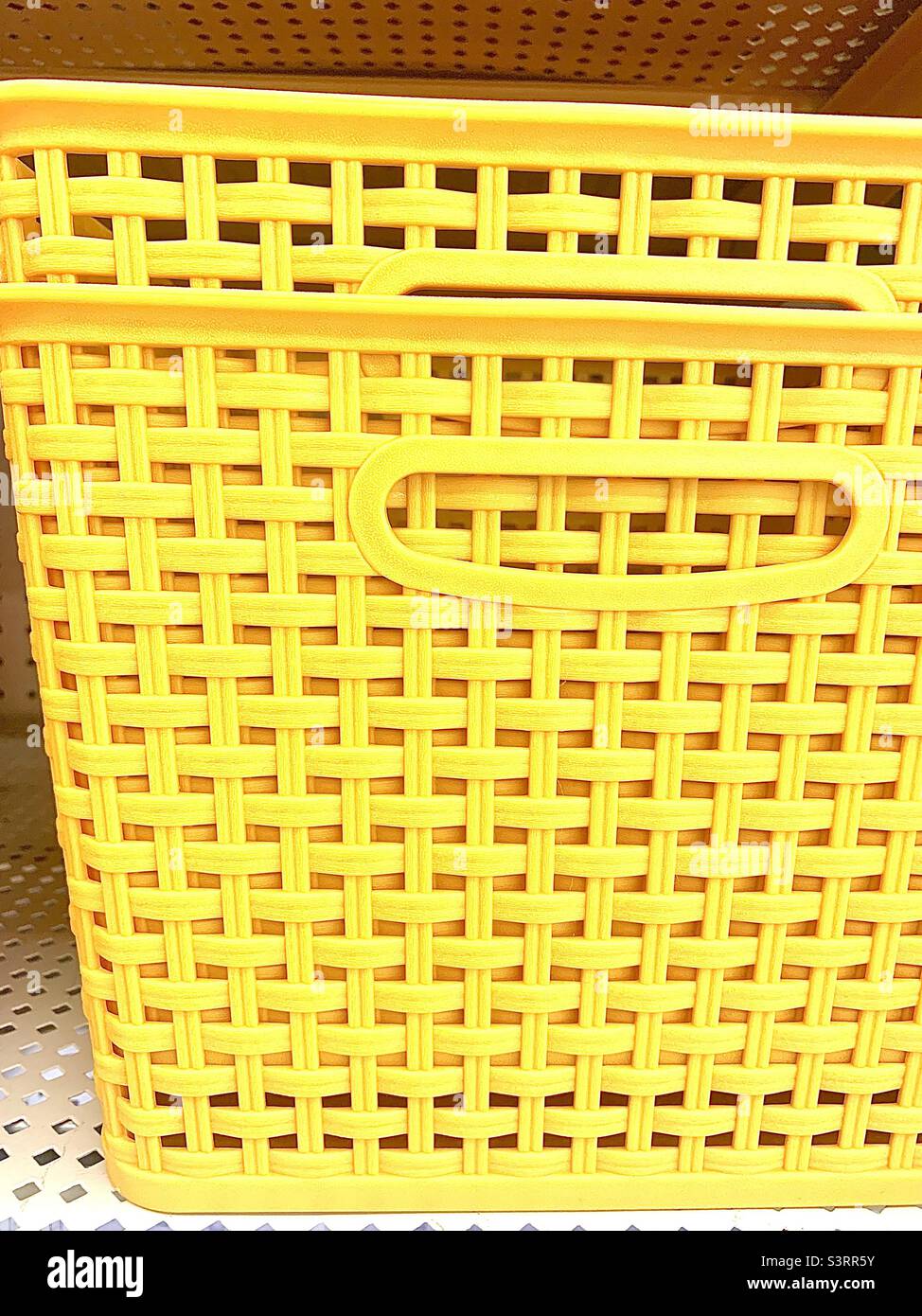 Stacked yellow weaved storage containers on shelf Stock Photo Alamy