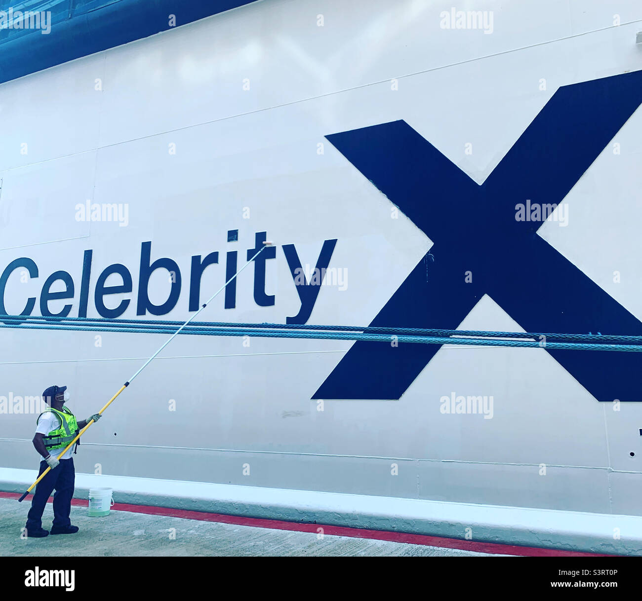 March, 2022, a worker cleans a Celebrity cruise ship in the port of Porto Plata, Dominican Republic - Smartphone Captured Stock Image