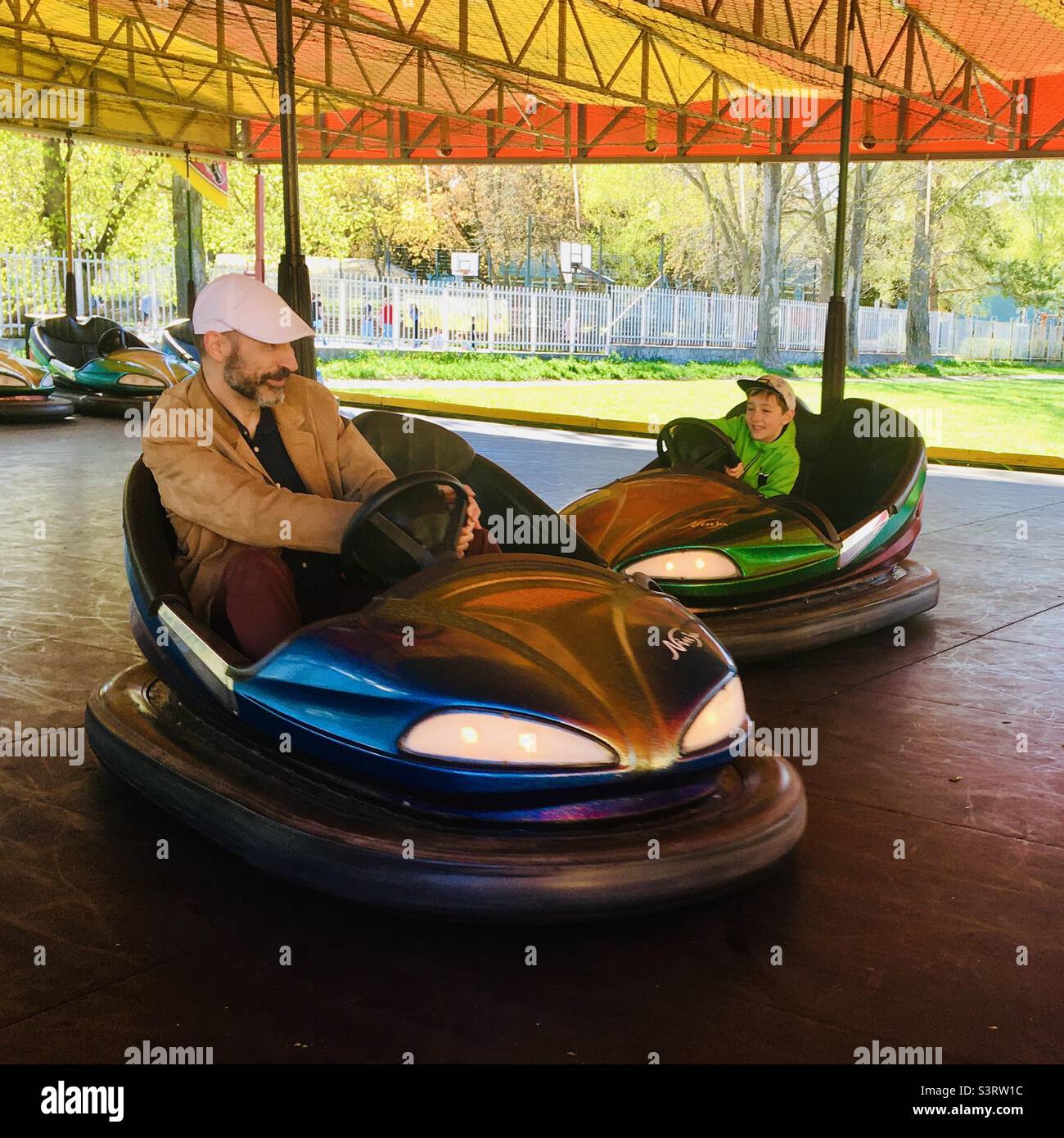Father and son riding dodgem bumper cars at funfair, Sopron, Hungary Stock Photo