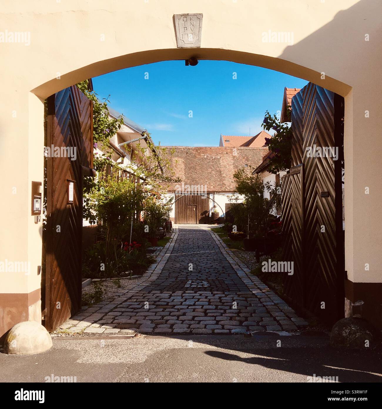 Yard of old house (built in 1774) with open gate, Ujteleki utca, Sopron, Hungary - Smartphone Captured Stock Image