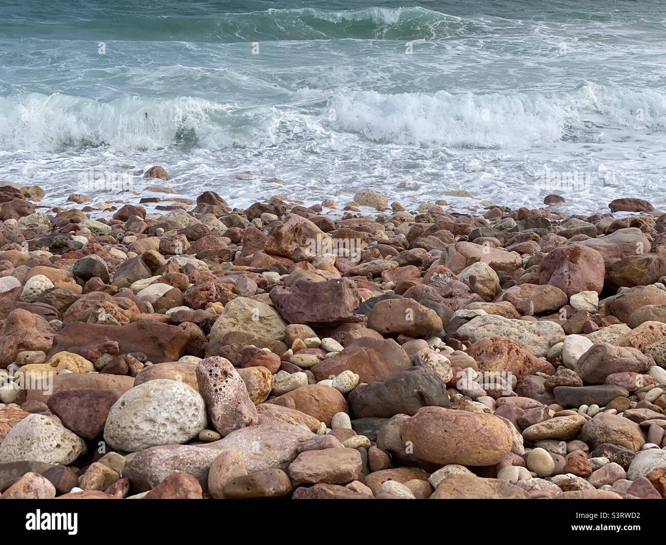 Gentle waves breaking on a rocky shore Stock Photo