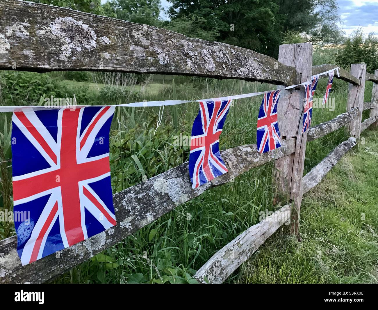 Jubilee Union Jack flags bunting hanging on wooden fence Stock Photo