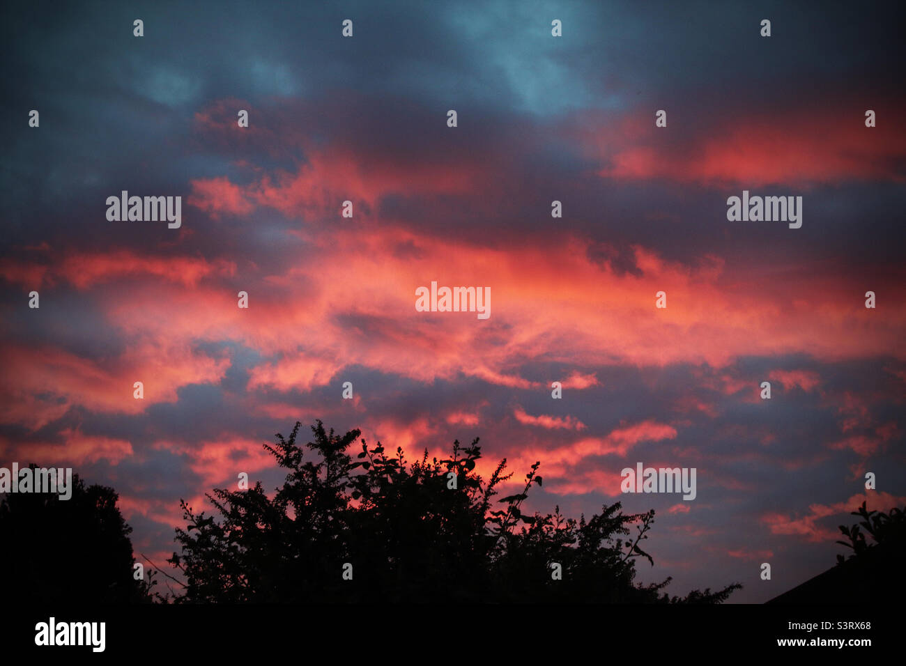 Dark, red and moody sunset over a small village - Smartphone Captured Stock Image