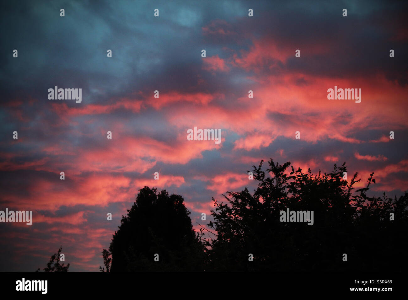Dark, red and moody sunset over a small village - Smartphone Captured Stock Image