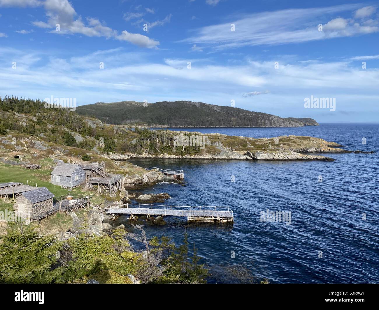 An old outport wharf in rural Newfoundland with wisps of clouds on the