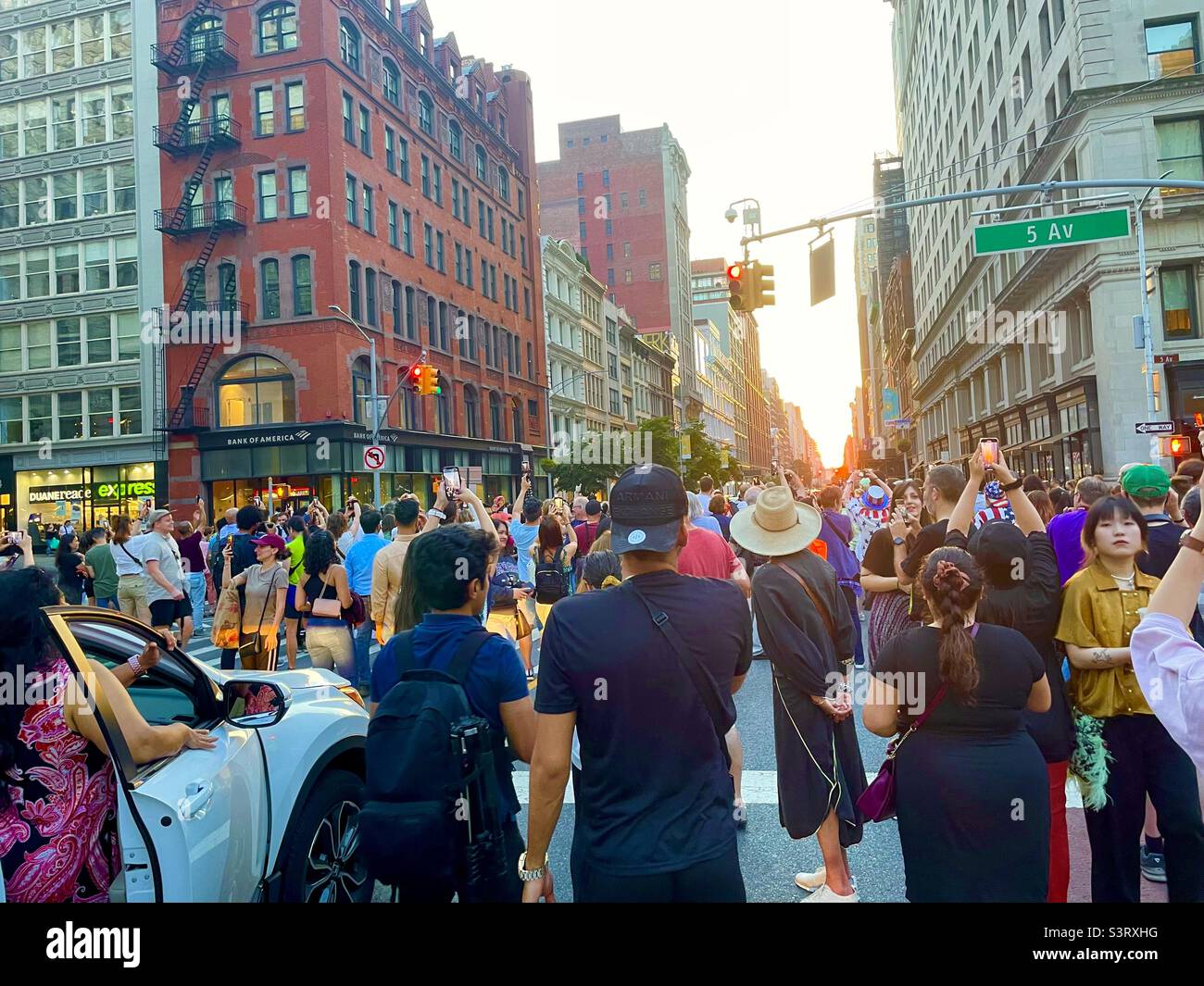 A crowd gathers in the streets for a viewing of the sunset Manhattanhenge Stock Photo