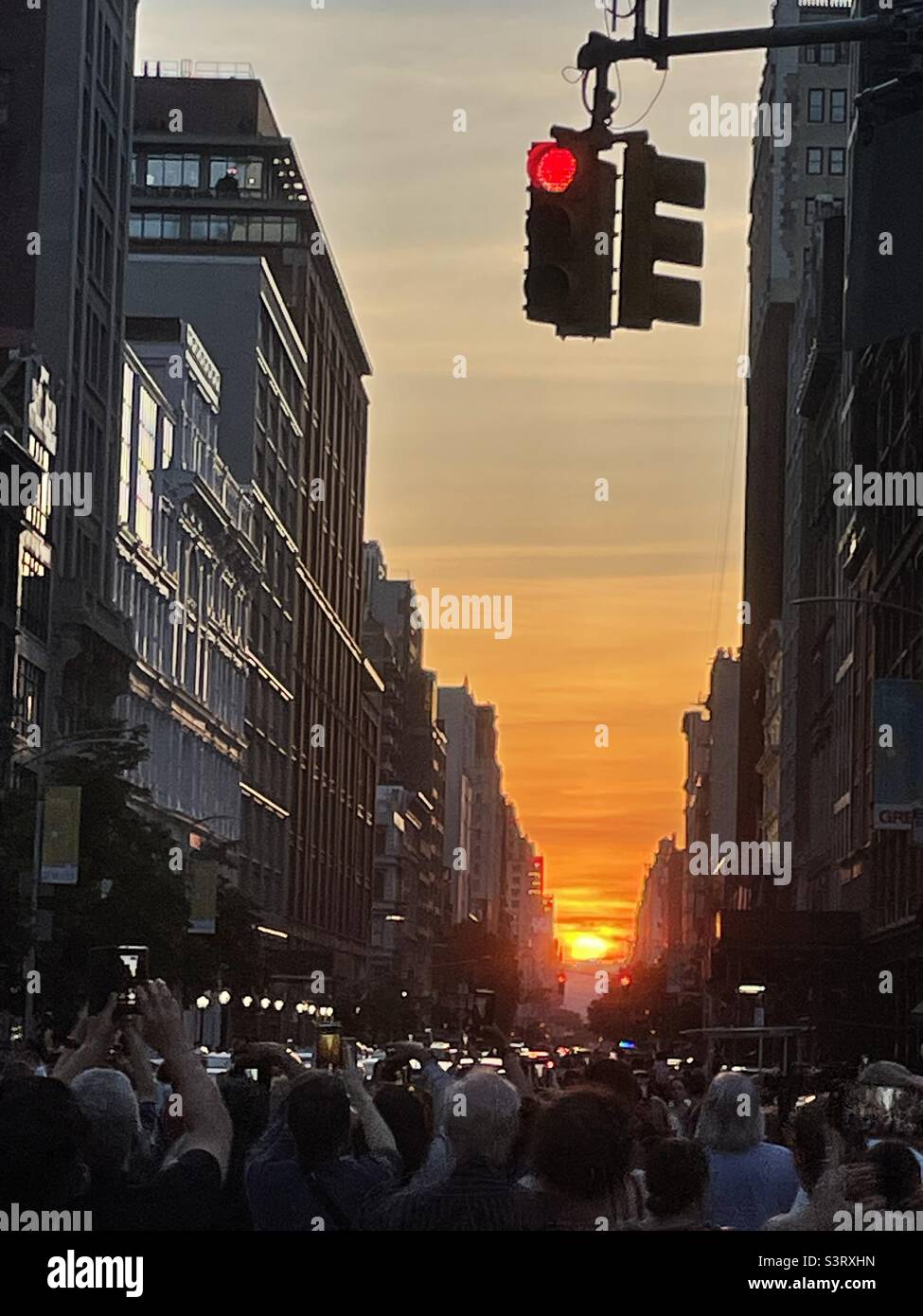 Crowd of people gather in the street at sunset to watch Manhattanhenge - Smartphone Captured Stock Image