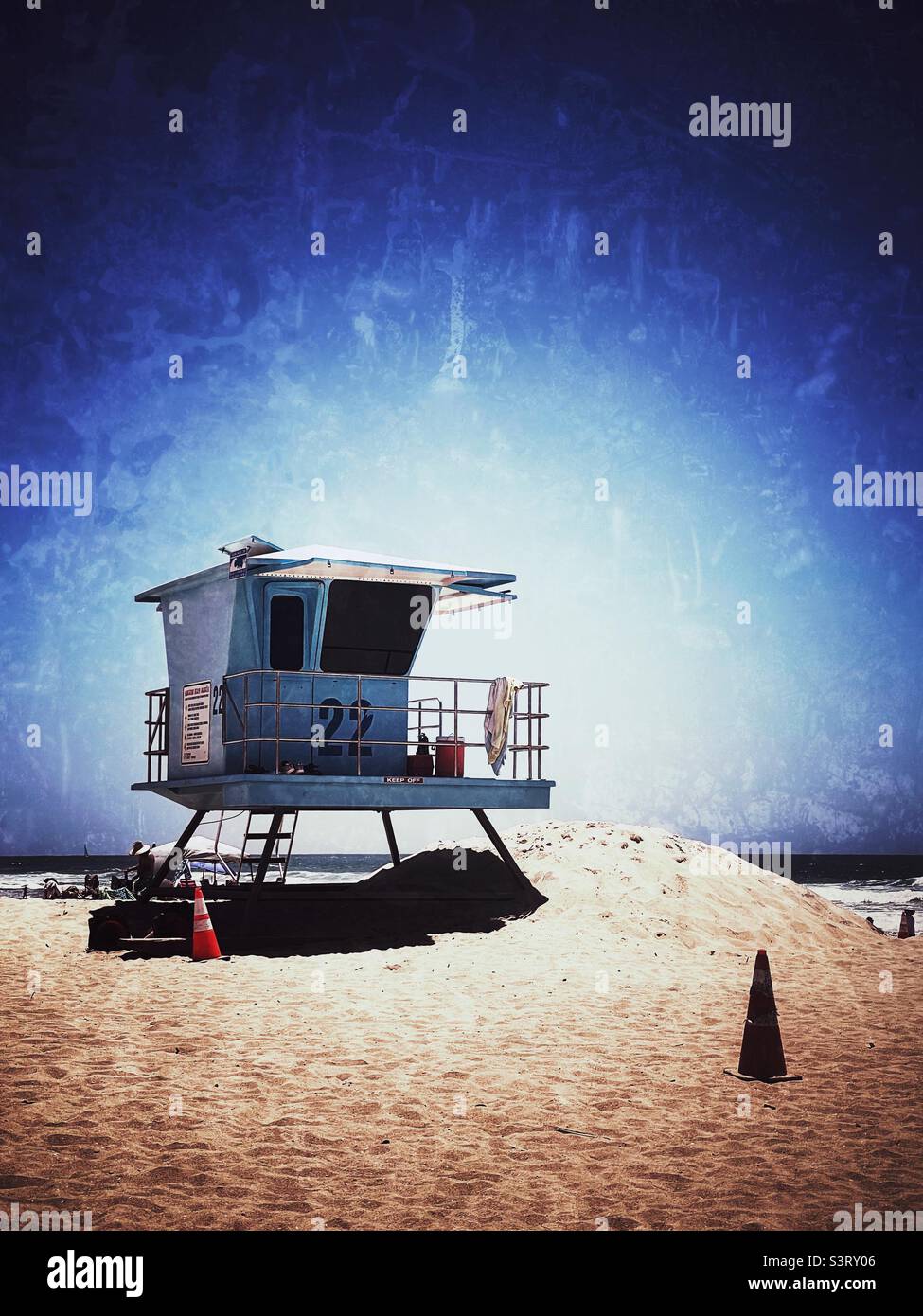 Lifeguard stand on sandy beach on a hot sunny day with ocean in the distance. Stock Photo
