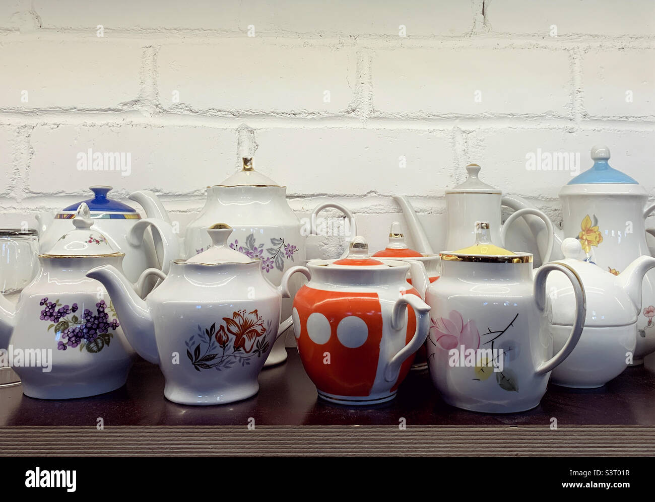Set of vintage teapots on wooden shelf - Smartphone Captured Stock Image