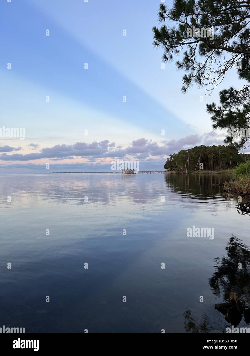 Large sun rays with reflections over bay water Stock Photo
