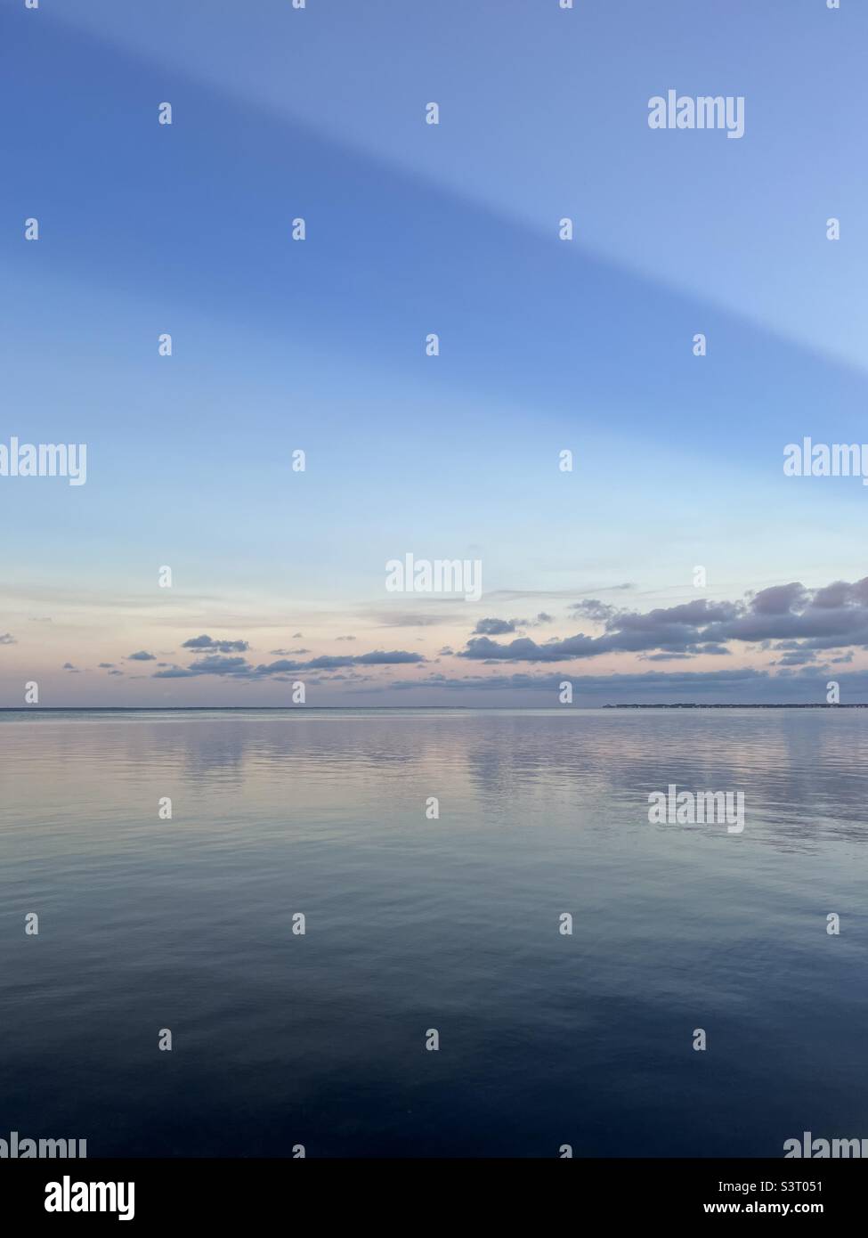 Large sun ray over bay water at sunset Stock Photo