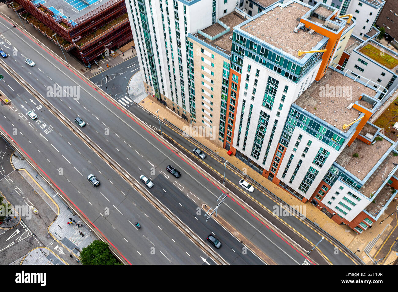 Looking down from above onto colourful and vibrant apartment blocks with roads running past into a large city - Smartphone Captured Stock Image