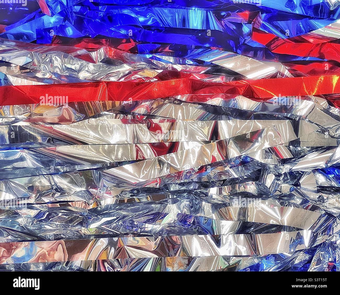 Sparkling tinsel streamers for sale at a local Utah Walmart for the upcoming holiday summer season. This Americana abstract has been digitally altered via the IOS app Snapseed, for artistic effect. - Smartphone Captured Stock Image