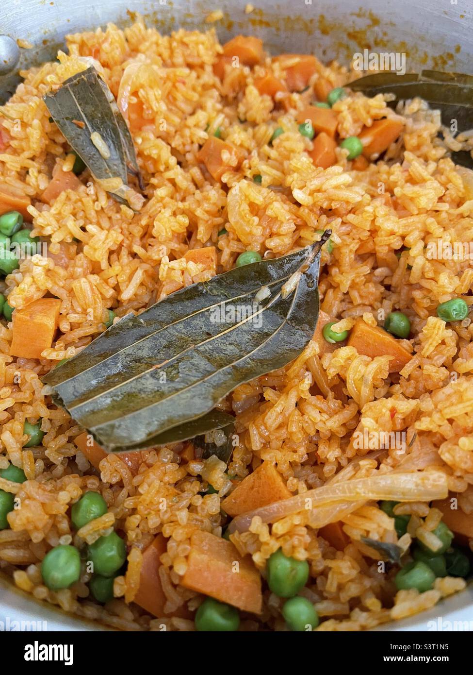 Jollof rice, Ghanaian rice dish made by cooking rice in a rich tomato sauce with herbs and spices Stock Photo