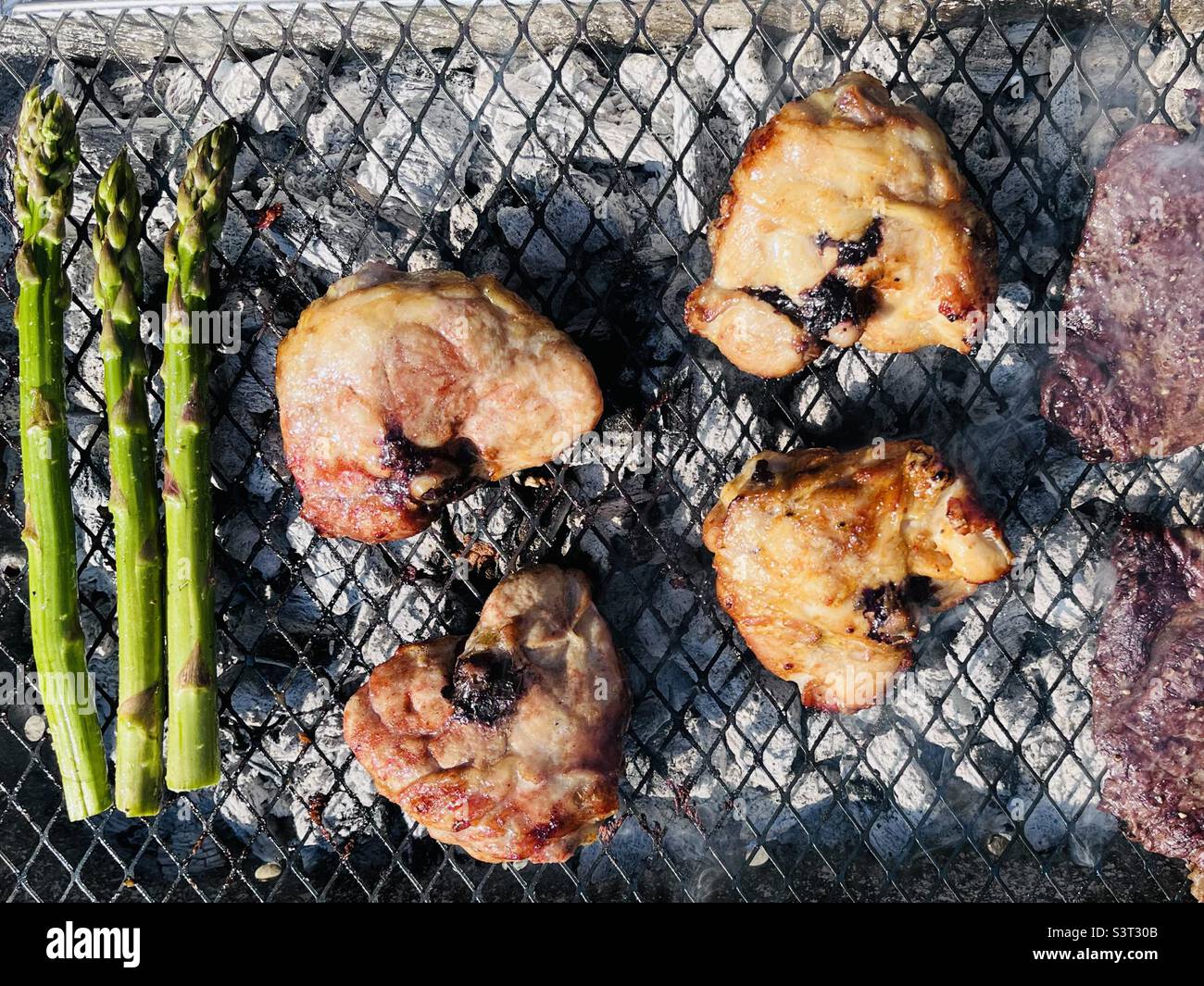 Asparagus chicken and beef steaks on a barbecue Stock Photo
