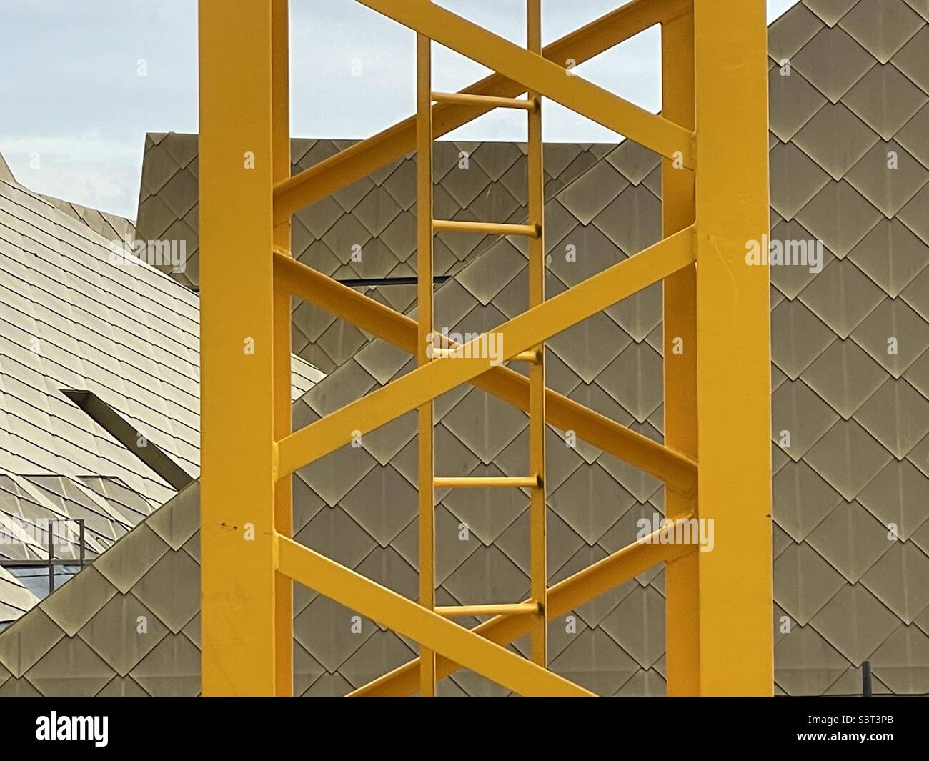 The steelwork of a yellow painted crane on a building site next to The Hive in Worcester Stock Photo