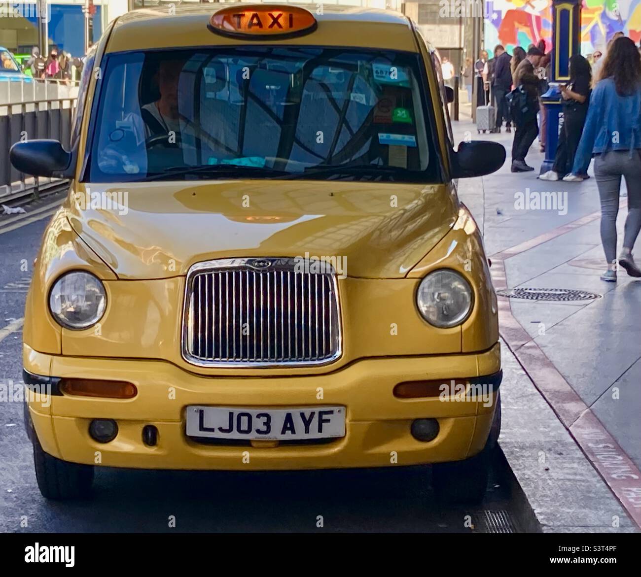 Front of a Yellow London taxi at the taxi rank at the front of Victoria Station London - Smartphone Captured Stock Image