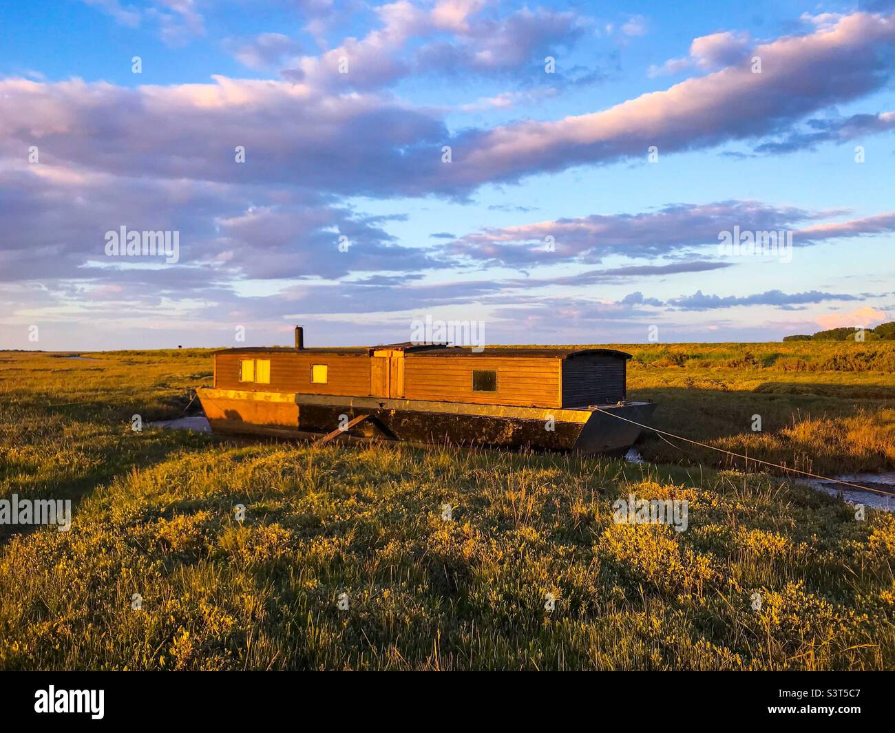 Old wooden boat on the mudflats at Burnham Deepdale in North Norfolk England UK. - Smartphone Captured Stock Image