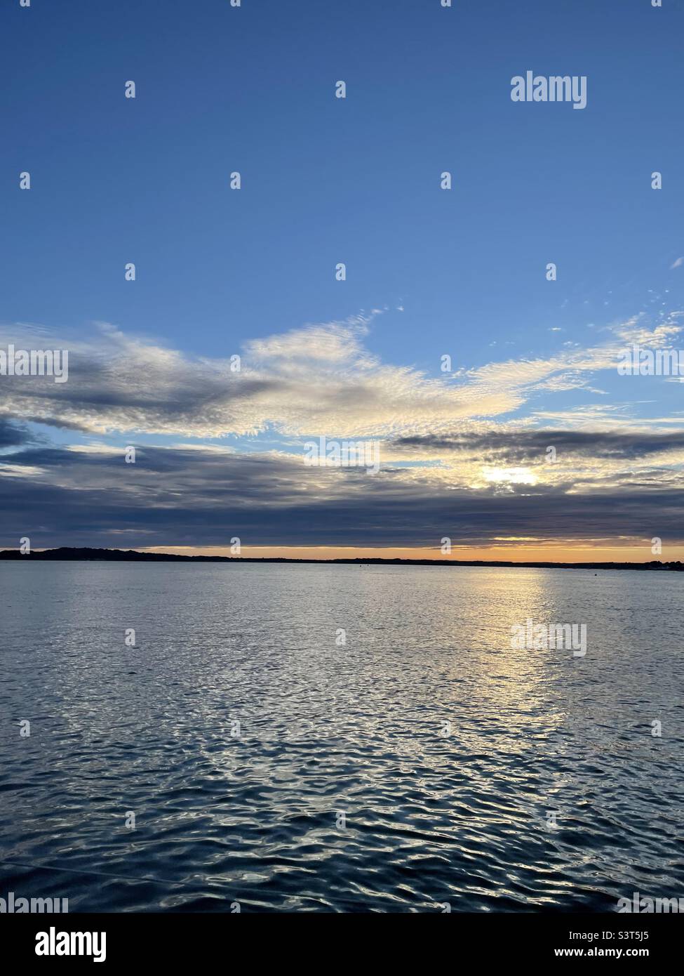 Summer sunset in Poole bay looking towards Upton and Wareham from