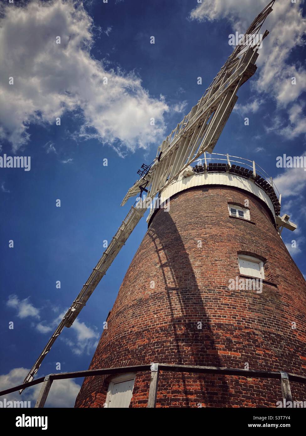 Looking up at the sails of a windmill against the sky. The windmill, known as John Webb’s windmill is located in Thaxted in Essex and was built in 1804 to grind flour. It is no longer a working mill. Stock Photo
