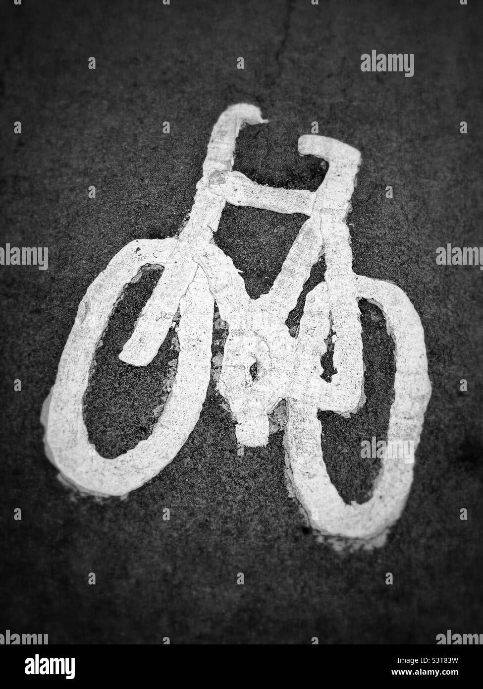 The logo picture of a bicycle painted onto a section of tarmac. This area is a designed bicycle lane. Photo ©️ COLIN HOSKINS. Stock Photo