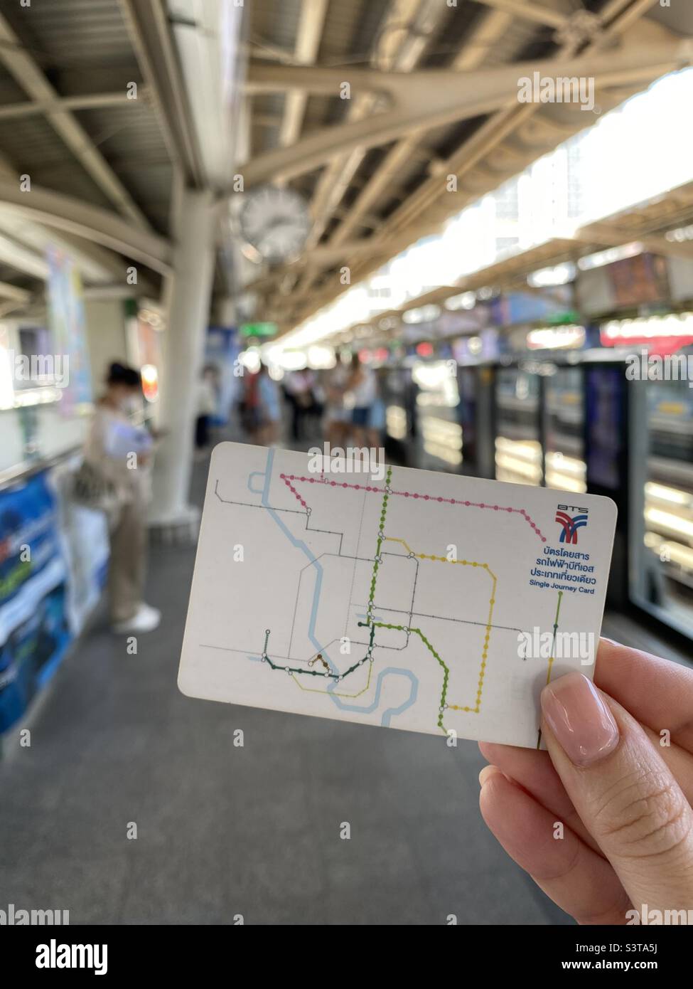 BTS one day pass and blurry skytrain station, on the Sukhumvit Line in Watthana District, Bangkok, Thailand. Stock Photo