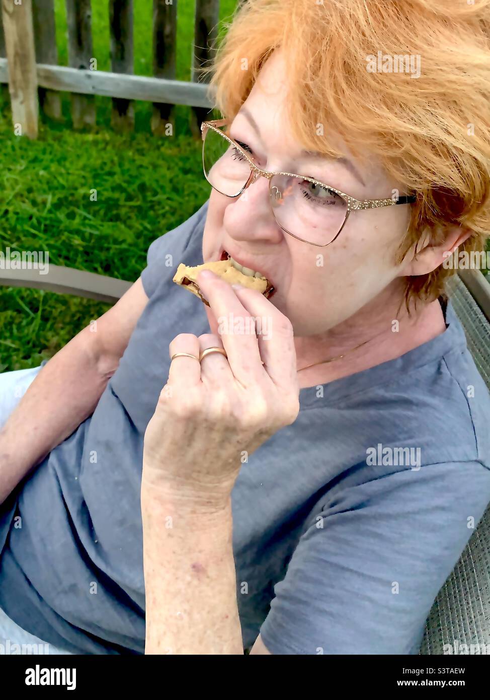 Mature woman eating S’mores Stock Photo
