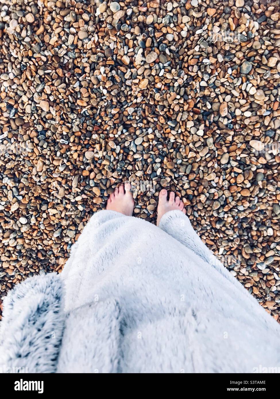 Wrapped up cosy in fluffy dressing gown after an early morning swim in the sea. Stock Photo
