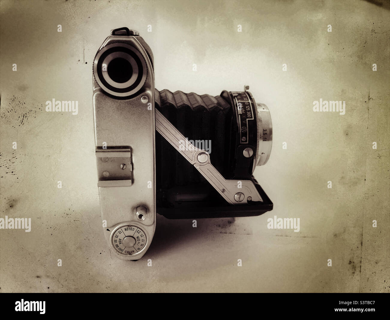 Vintage folding photographic camera photographed from side view. Image edited to give it vintage look Stock Photo