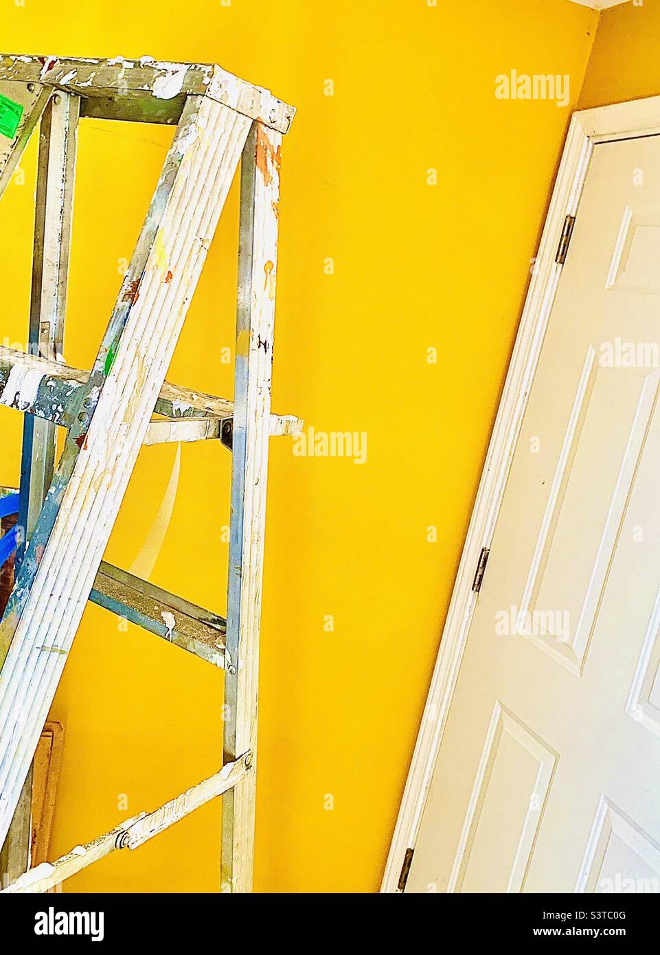 Ladder with paint splatter. White door Stock Photo