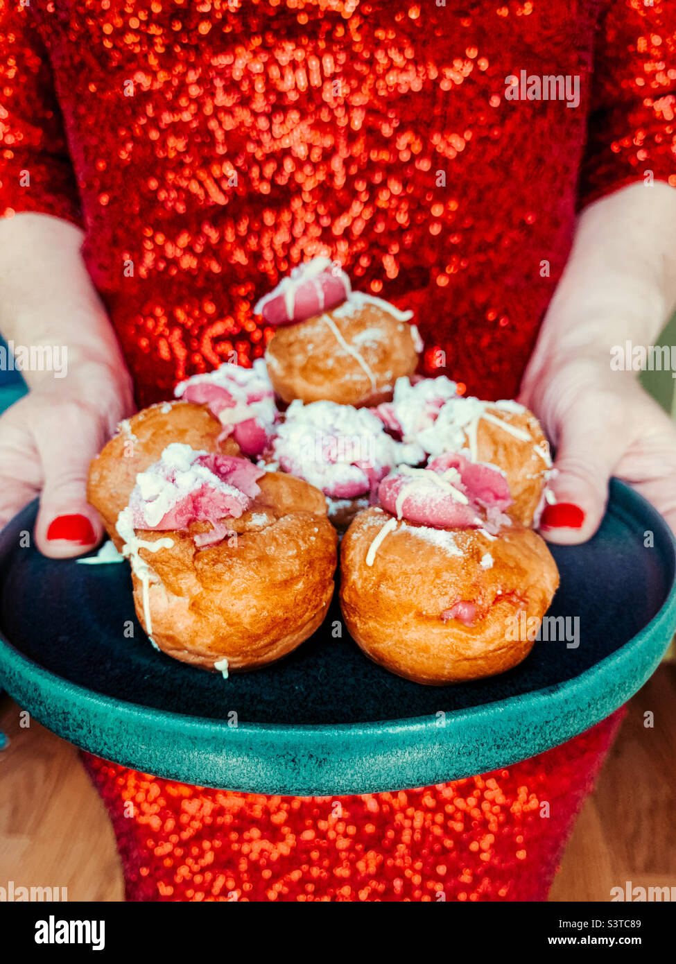 Woman holding a plate of profiteroles - Smartphone Captured Stock Image