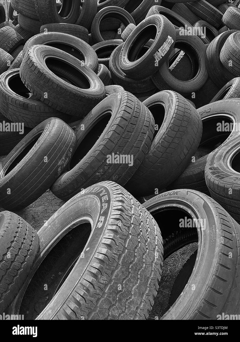 A bunch of old and worn tires piled up behind a car/tire shop in Utah, USA. Desaturating to black and white and adding some contrast makes for an interesting abstract. - Smartphone Captured Stock Image A bunch of old and worn tires piled up behind a car/tire shop in Utah, USA. Desaturating to black and white and adding some contrast makes for an interesting abstract. - Smartphone Captured Stock Image