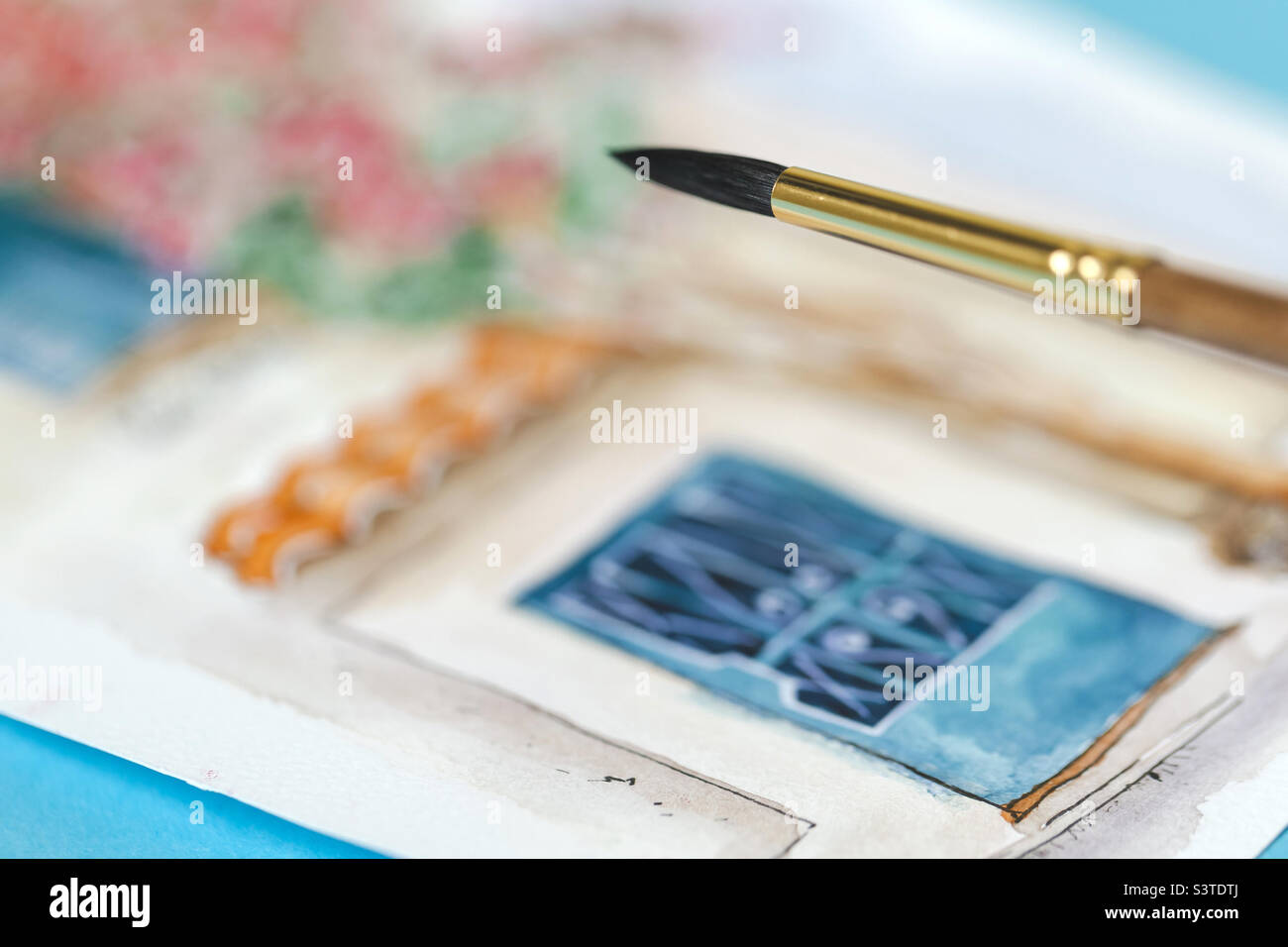 Artist brush closeup with backdrop of watercolor painting Stock Photo
