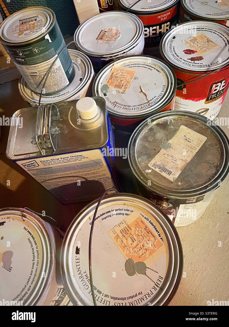 Stored previously opened paint cans in a suburban home basement, 2022