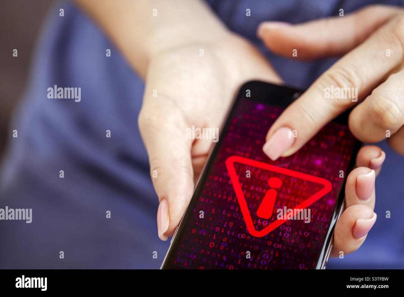 Mobile phone in female hands with screen showing compromised by virus infected device. Cyber attack. Stock Photo