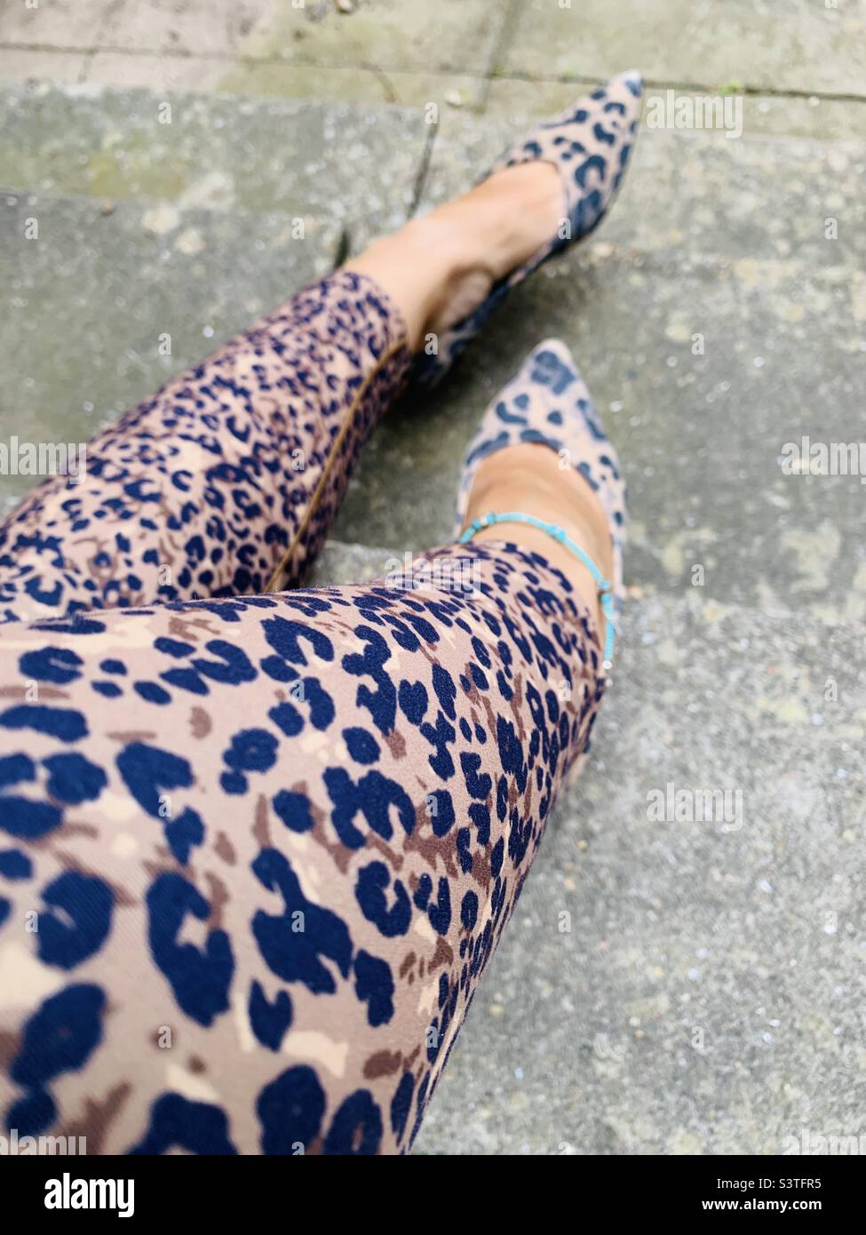 Woman wearing leopard print leggings and shoes Stock Photo