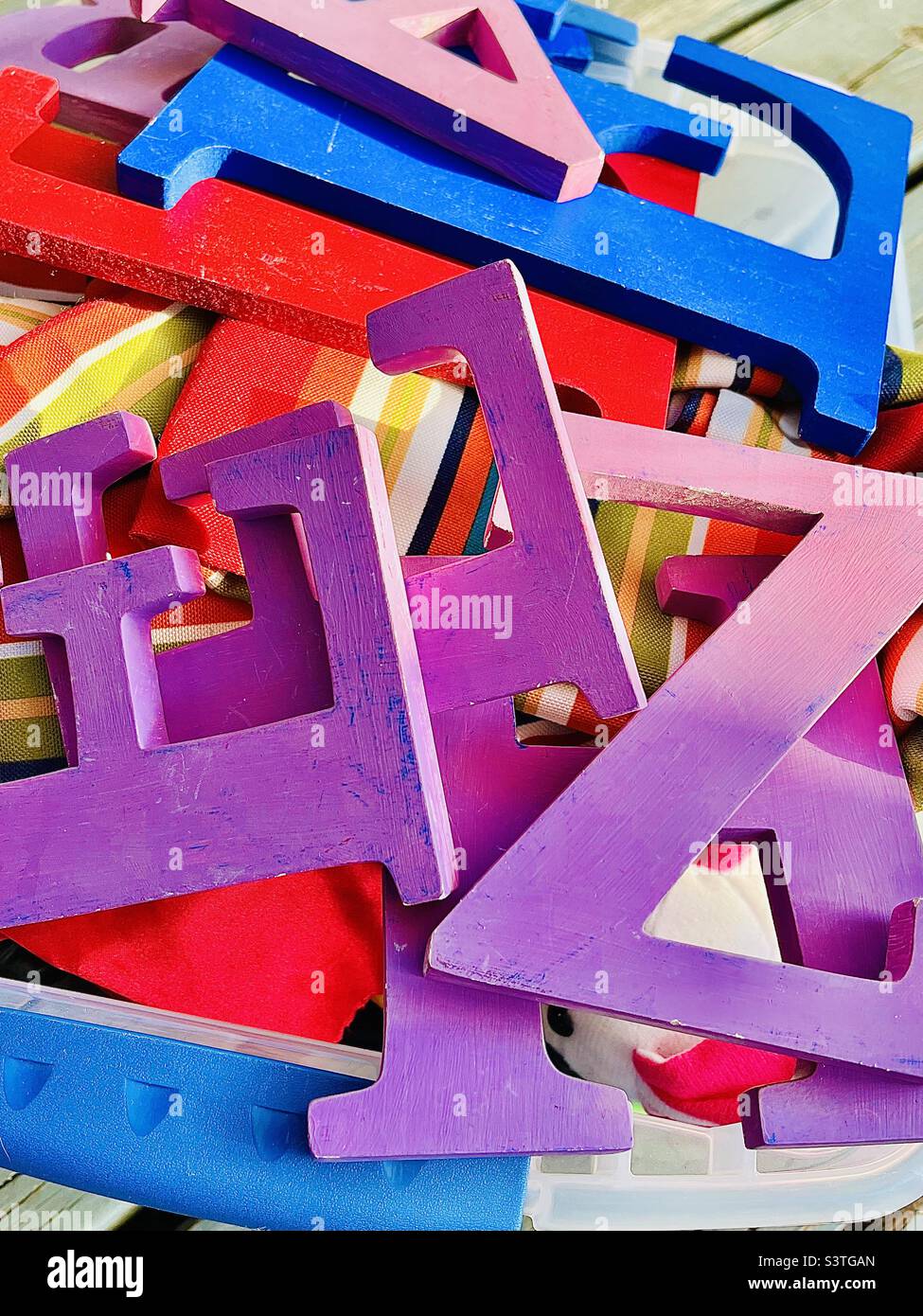 Box of colorfully painted wooden letters Stock Photo