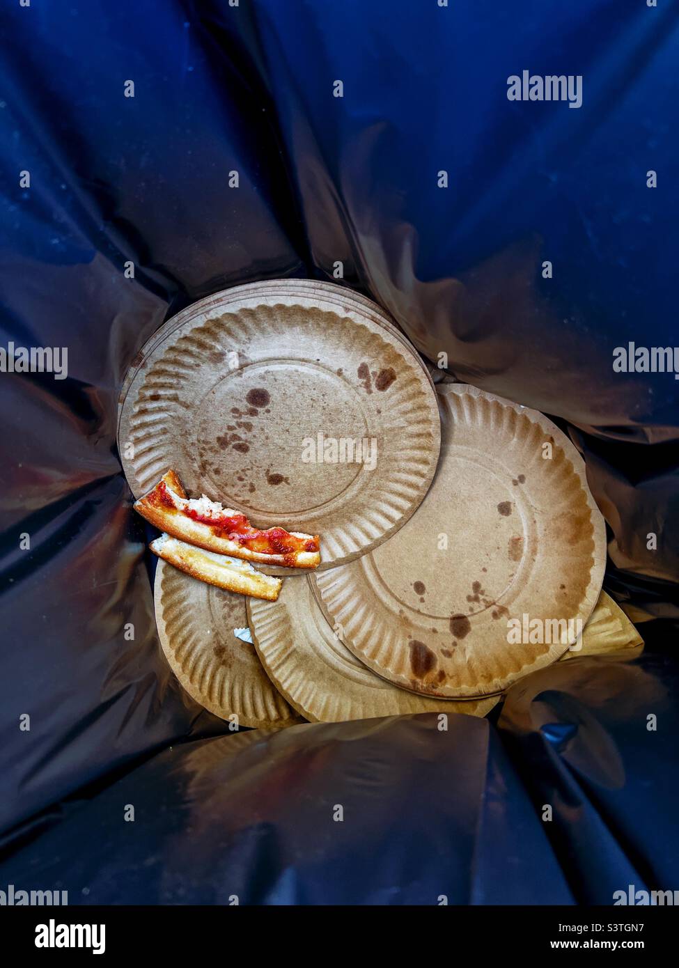 Trash bin at public event with paper plates and pizza crust - Smartphone Captured Stock Image