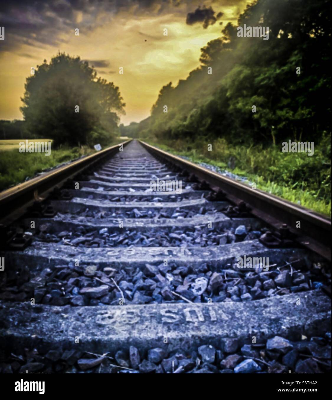 Amazing photo by the train tracks and the sunset Stock Photo