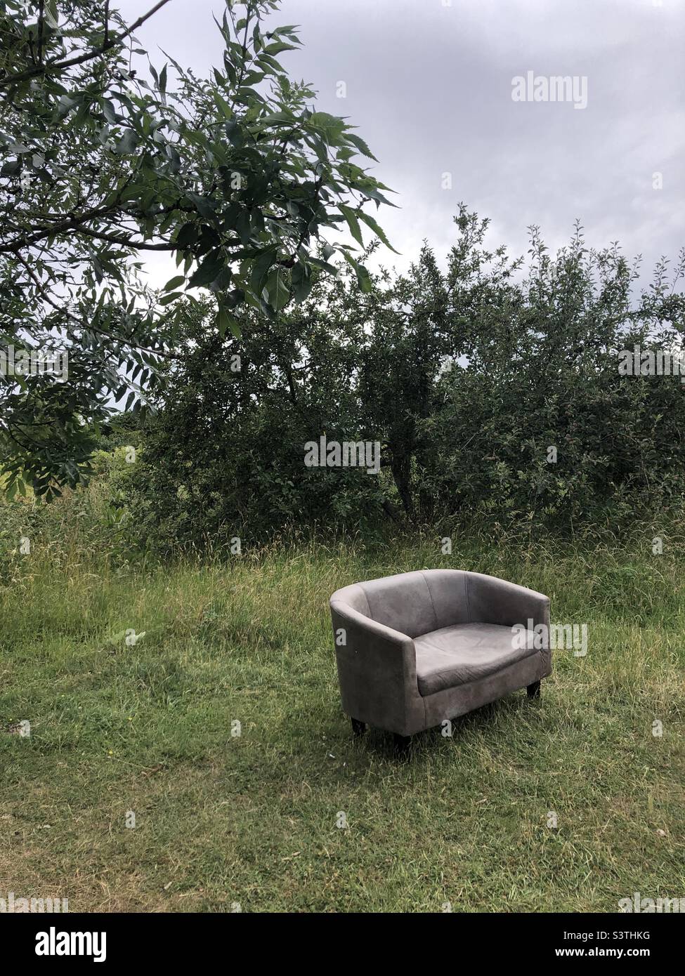 Sofa left in a field Stock Photo