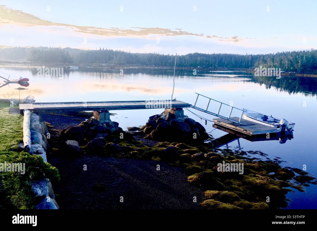 Boats moored on an inlet of the Atlantic Ocean, Nova Scotia, Canada. Beginning of a lovely day in early summer. - Smartphone Captured Stock Image