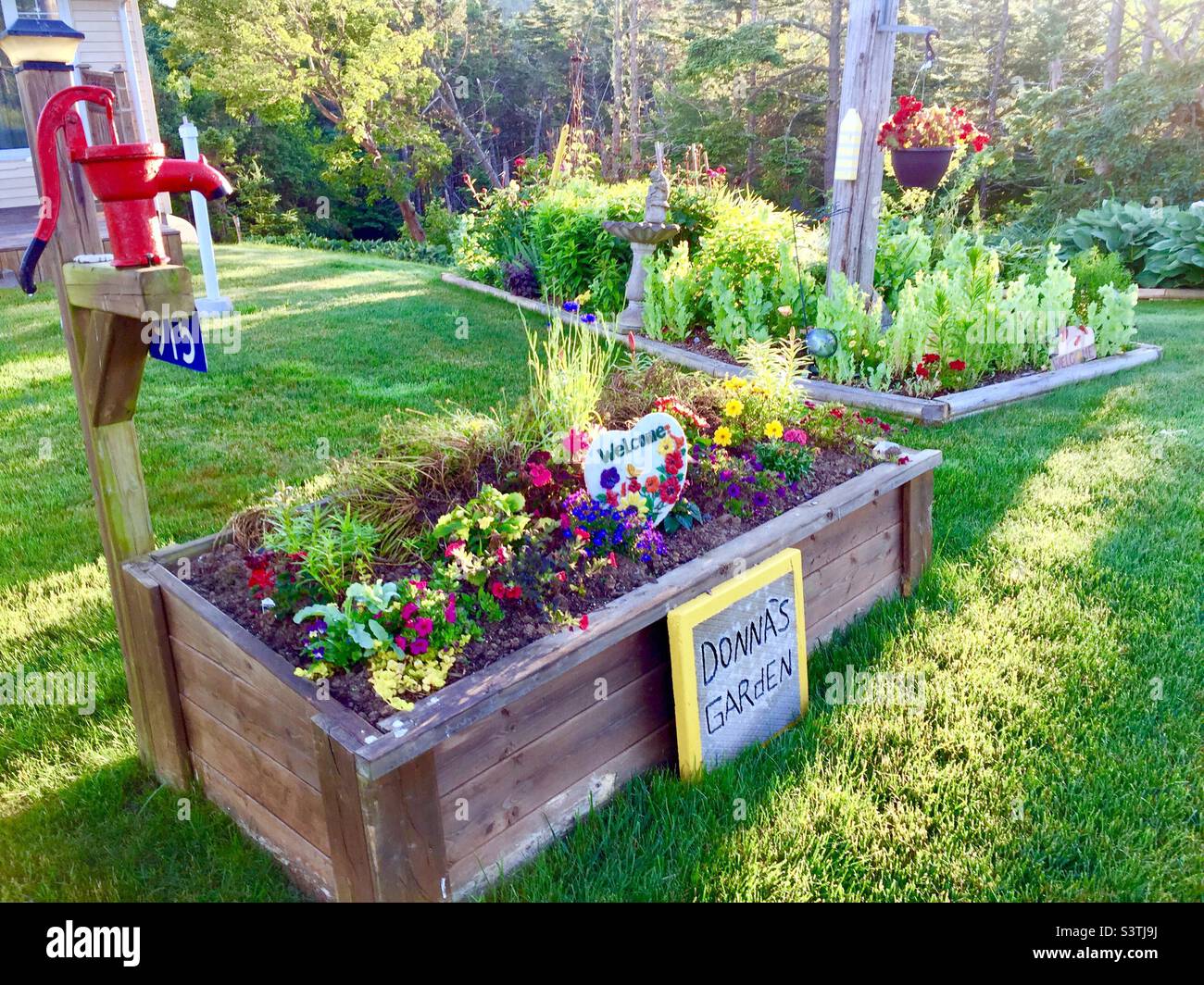 Small, quaint, garden, a hand pump for show, and a raised flower bed